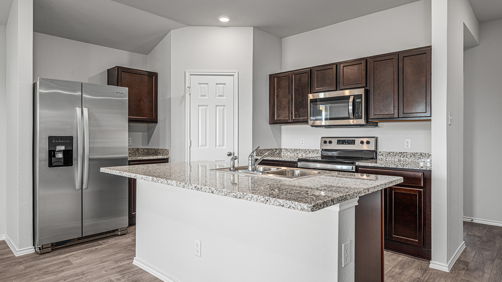 1303 Coriander Road Temple, TX 76501 - Photo 7 of 20 Kitchen island with a double basin sink, stainless steel faucet, and granite countertop