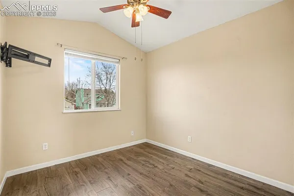an empty room with a window and wooden floor