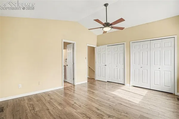 a view of a room with wooden floor closet ceiling fan and window