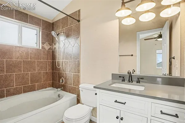 a bathroom with a granite countertop sink a toilet and bathtub
