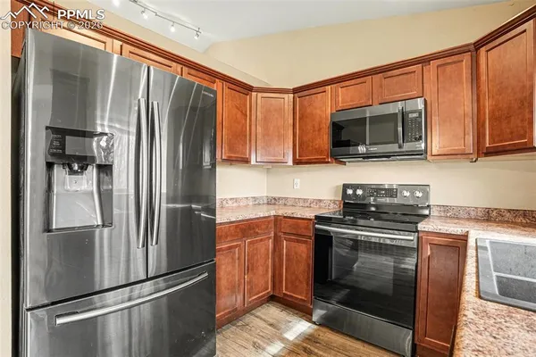 a kitchen with stainless steel appliances granite countertop a refrigerator stove and microwave