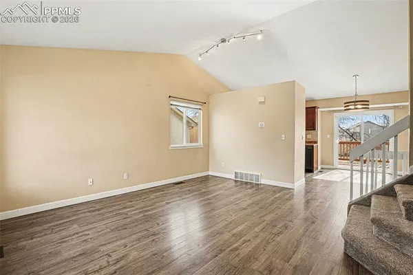 an empty room with wooden floor and a window