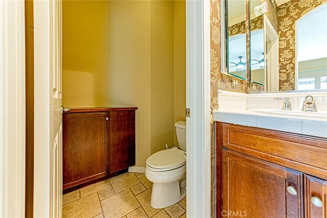 a bathroom with a granite countertop toilet and a sink