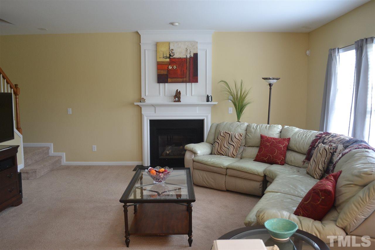 5423 Shaker Heights Lane Raleigh, NC 27613 - Photo 13 of 24 a living room with furniture a fireplace and a flat screen tv