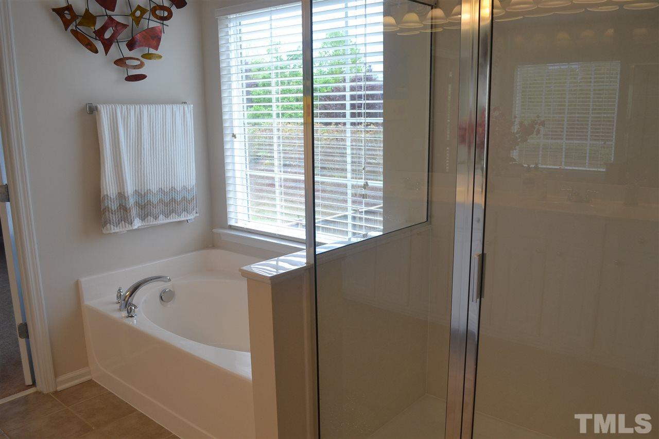 5423 Shaker Heights Lane Raleigh, NC 27613 - Photo 18 of 24 a bathroom with a bathtub and window