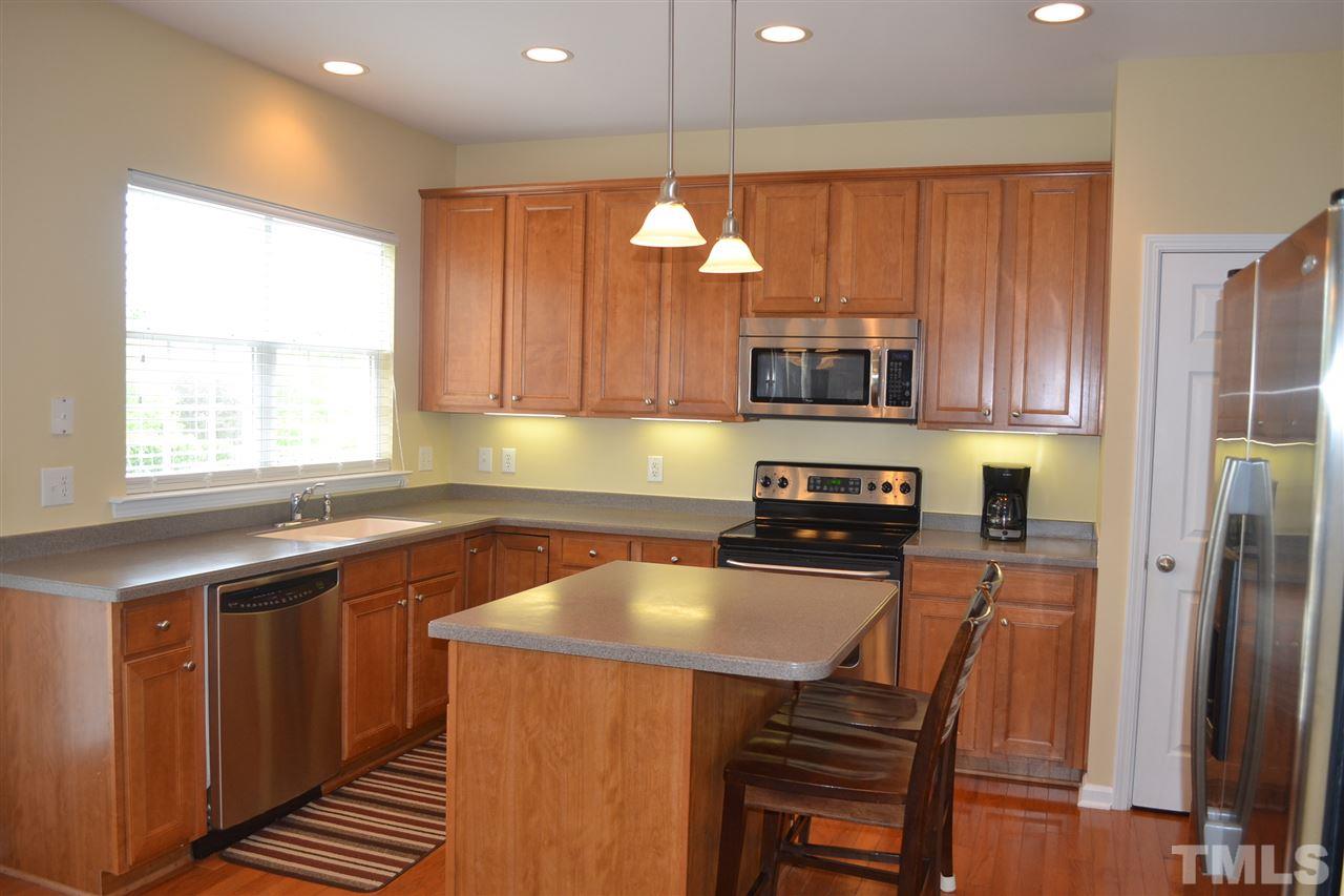5423 Shaker Heights Lane Raleigh, NC 27613 - Photo 8 of 24 a kitchen with a sink a microwave a refrigerator and cabinets