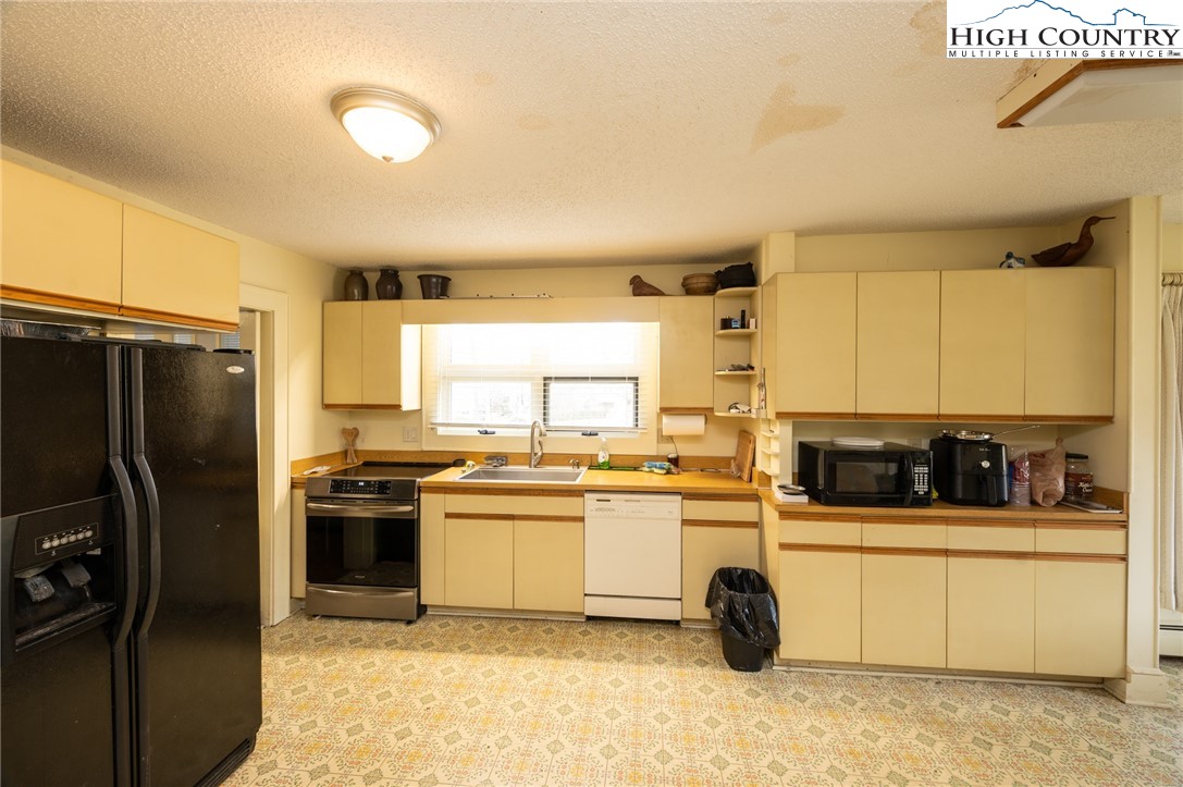 4634 Highway 421 Vilas, NC 28692 - Photo 21 of 28 a kitchen with stainless steel appliances kitchen island granite countertop a stove refrigerator and cabinets