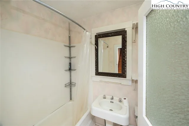 a bedroom with a bed and a flat tv screen on dresser