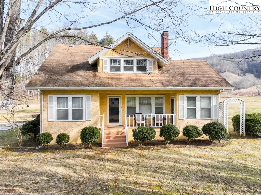 4634 Highway 421 Vilas, NC 28692 - Photo 3 of 28 a view of a brick house with a yard plants and large tree