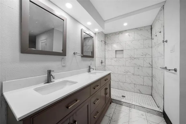 a bathroom with a sink shower and a mirror