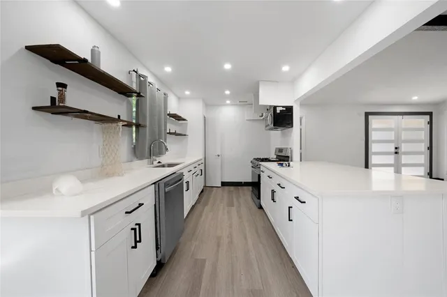 a large kitchen with stainless steel appliances granite countertop a stove and a sink
