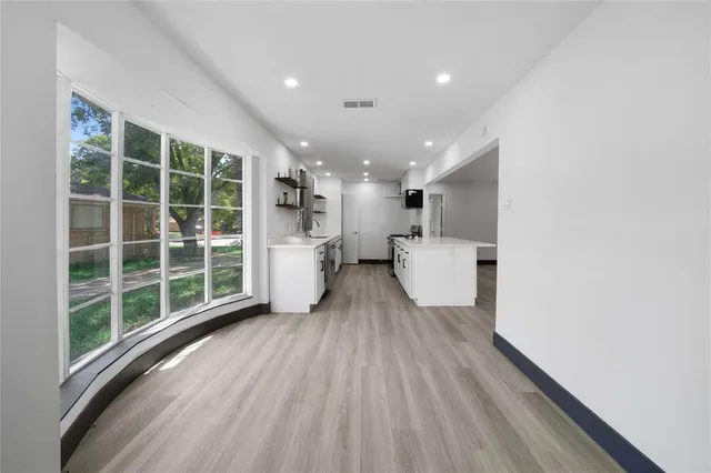 a view of an empty room with wooden floor and closet