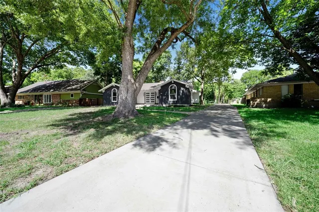 a view of a backyard with table and chairs and a large tree