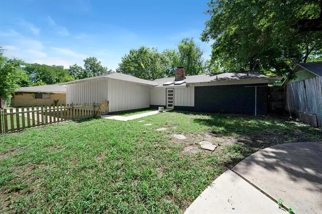 a view of a backyard with wooden fence