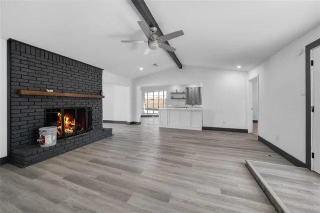 a view of empty room with wooden floor and fireplace