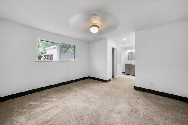 an empty room with windows and bathroom