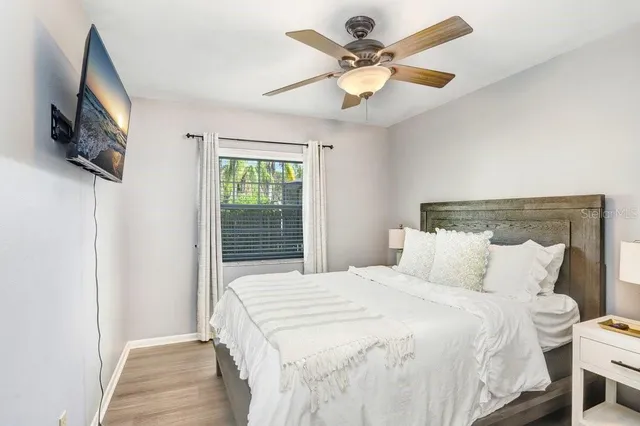 a bedroom with a large bed and a flat tv screen on dresser