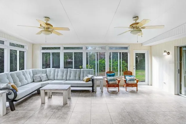 a living room with furniture ceiling fan and a large window