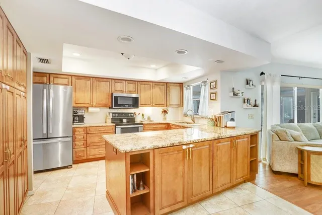 a kitchen with stainless steel appliances granite countertop a refrigerator and a sink