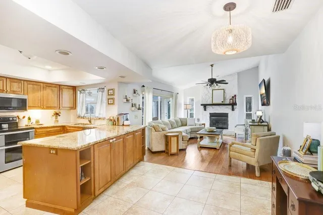 a large white kitchen with lots of counter top space a sink appliances and cabinets