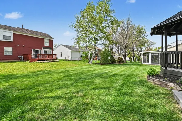 a view of a house with a big yard and large trees