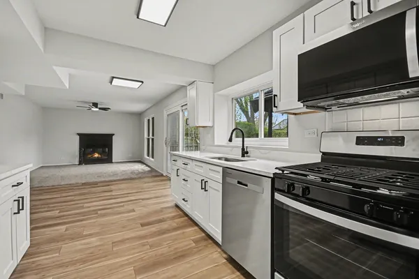 a kitchen with stainless steel appliances kitchen island granite countertop a stove and a sink