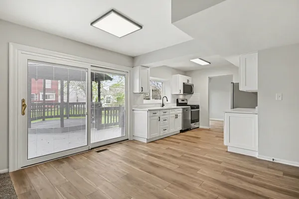 a kitchen with stainless steel appliances a sink cabinets and wooden floor