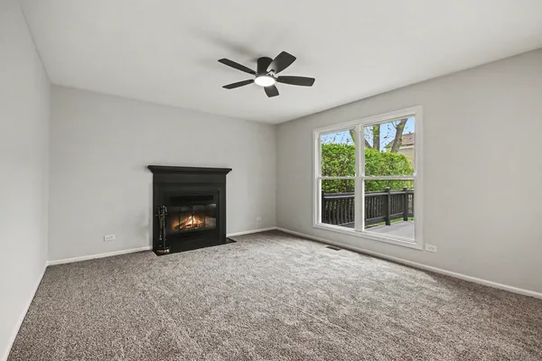 an empty room with windows and fireplace