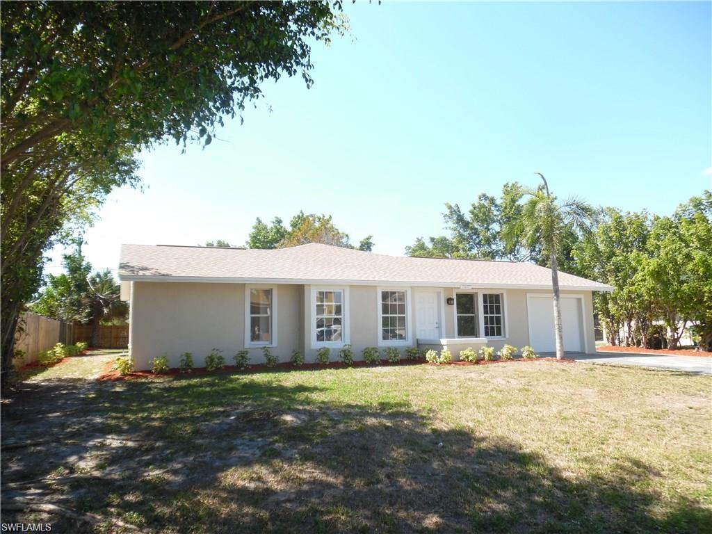 3055 52nd Street Southwest Naples, FL 34116 - Photo 1 of 21 a front view of a house with a yard and trees