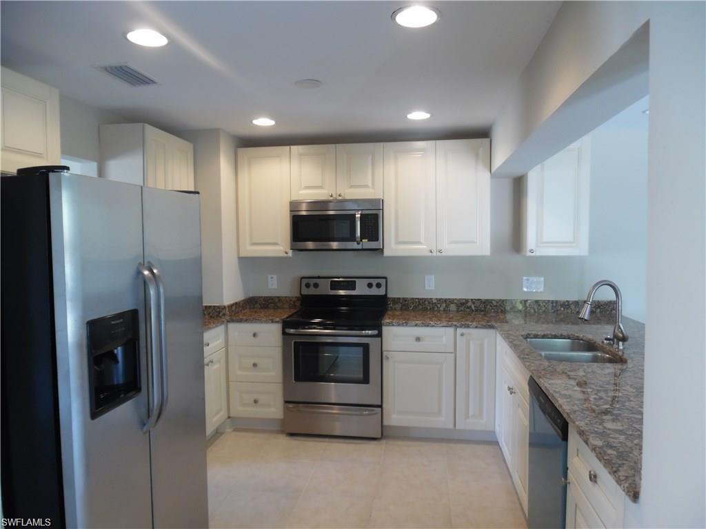 3055 52nd Street Southwest Naples, FL 34116 - Photo 4 of 21 a kitchen with a sink stove and refrigerator