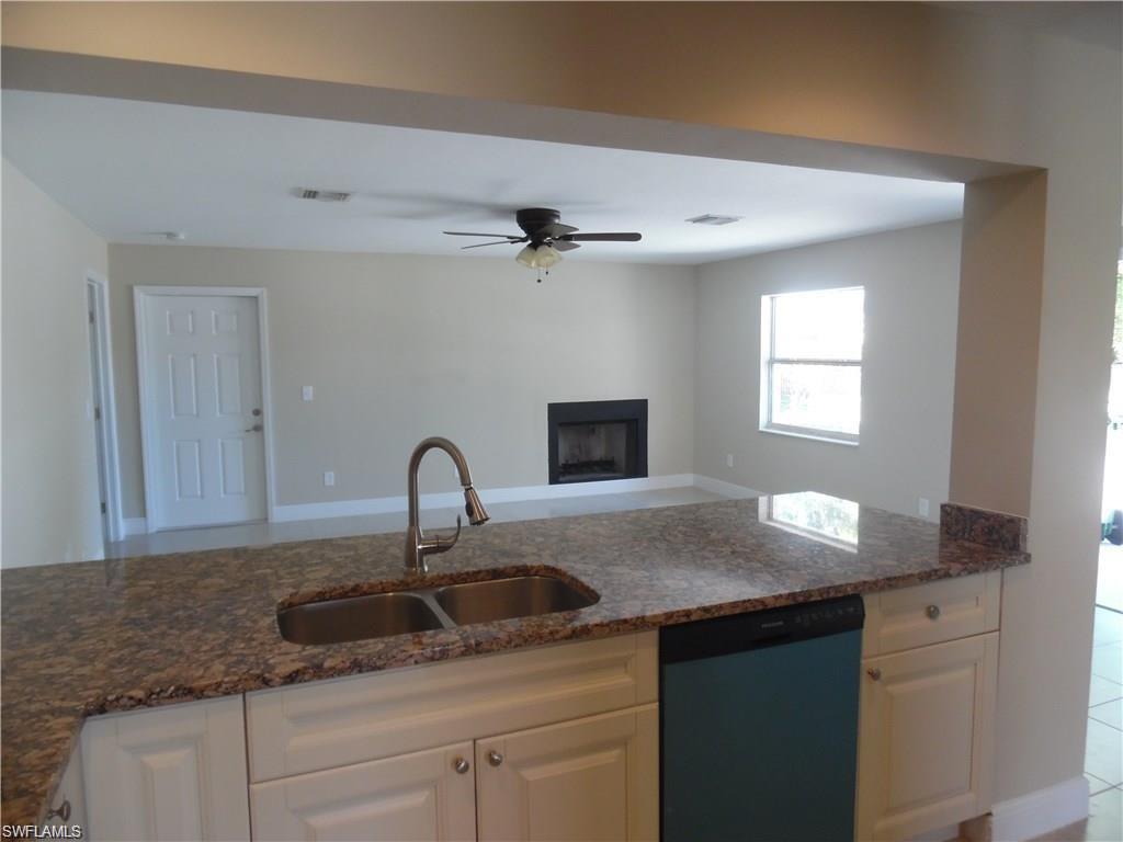 3055 52nd Street Southwest Naples, FL 34116 - Photo 5 of 21 a kitchen with granite countertop a sink cabinets and stainless steel appliances