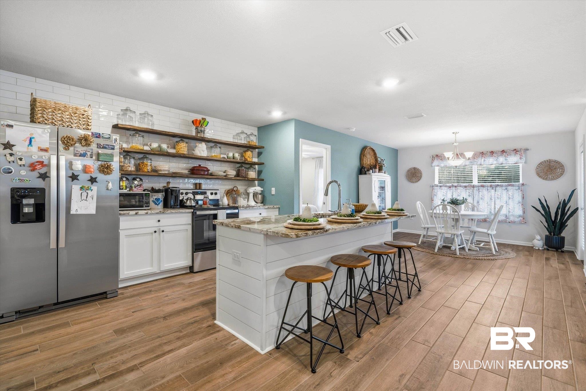 17041 Muse Street Loxley, AL 36551 - Photo 6 of 44 Kitchen featuring open shelves, stainless steel appliances, white cabinets, light wood-type flooring, and light stone countertops