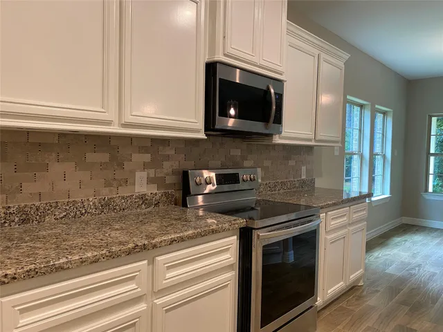 a bathroom with a granite countertop sink toilet mirror and shower