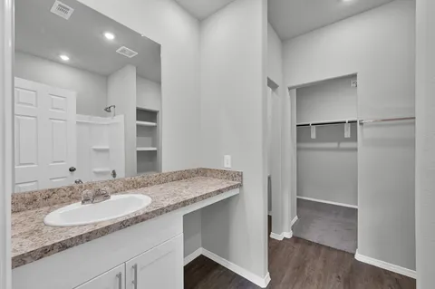 a bathroom with a granite countertop sink and a mirror