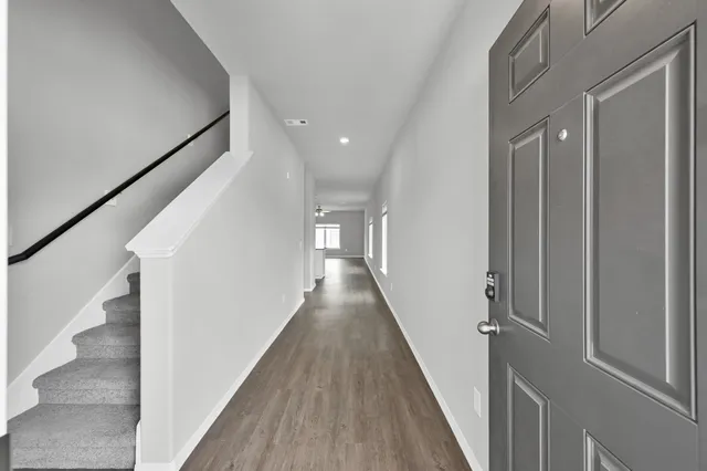 a view of a hallway with wooden floor and staircase