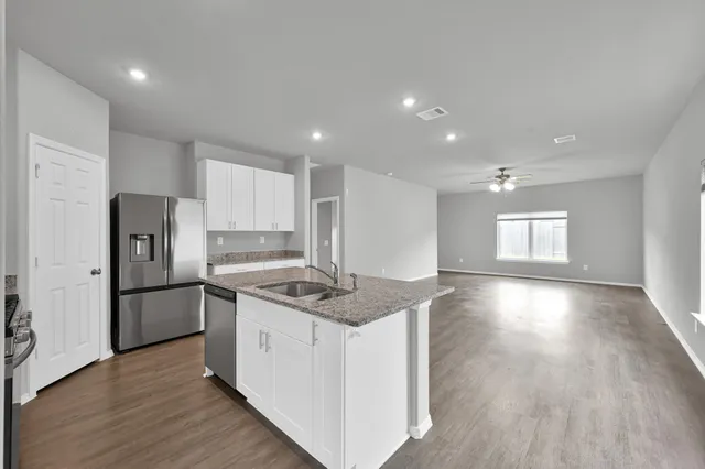 a kitchen with stainless steel appliances granite countertop a sink stove and refrigerator