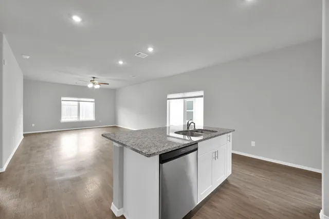 a kitchen with stainless steel appliances granite countertop a sink stove and cabinets