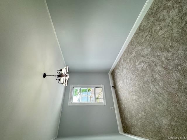 44-11 65th Street Queens, NY 11377 - Photo 18 of 29 an empty room with a chandelier fan and windows