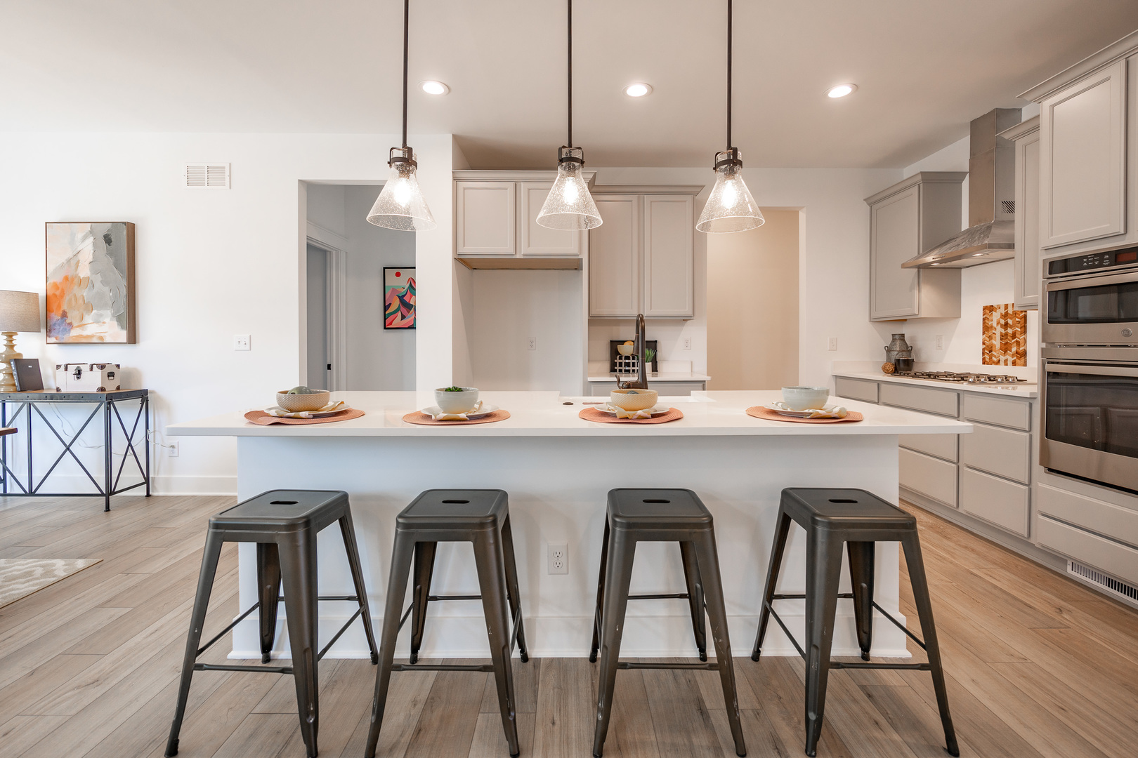 283 Wild Prairie Pointe Hampshire, IL 60140 - Photo 9 of 32 a kitchen with stainless steel appliances granite countertop a table chairs stove and wooden floor