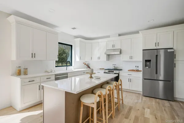 a kitchen with stainless steel appliances granite countertop a sink stove and refrigerator