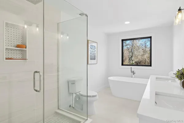 a bathroom with a tub sink shower and mirror