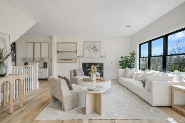 a living room with furniture a large window and a fireplace