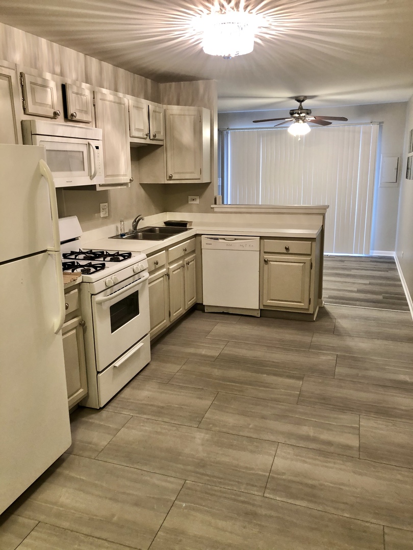 1769 Raleigh Lane Hoffman Estates, IL 60169 - Photo 4 of 17 a kitchen with a stove top oven cabinets and a refrigerator