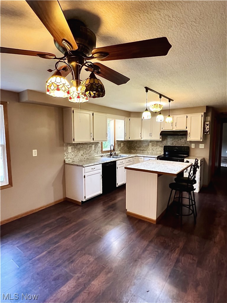 3122 Bedrock Road Northwest Dellroy, OH 44620 - Photo 13 of 23 Kitchen featuring ceiling fan with notable chandelier, dark hardwood / wood-style flooring, white cabinets, and black range with electric cooktop