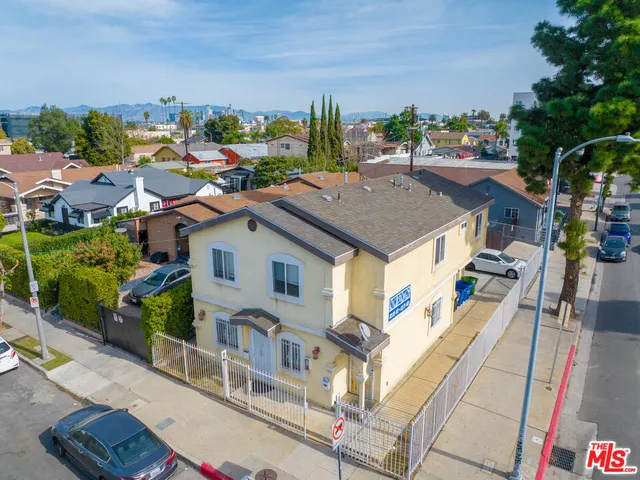 a aerial view of a house with a big yard and potted plants