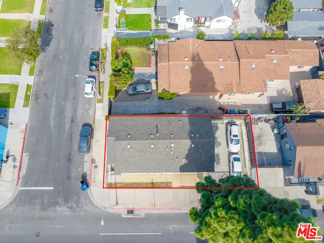 an aerial view of residential houses with outdoor space and parking
