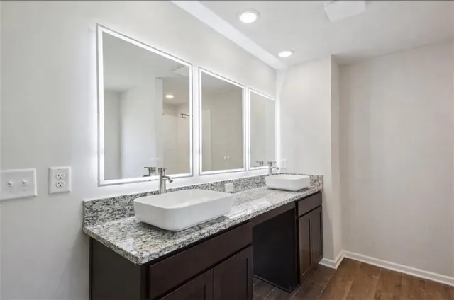 a bathroom with a granite countertop sink and a mirror