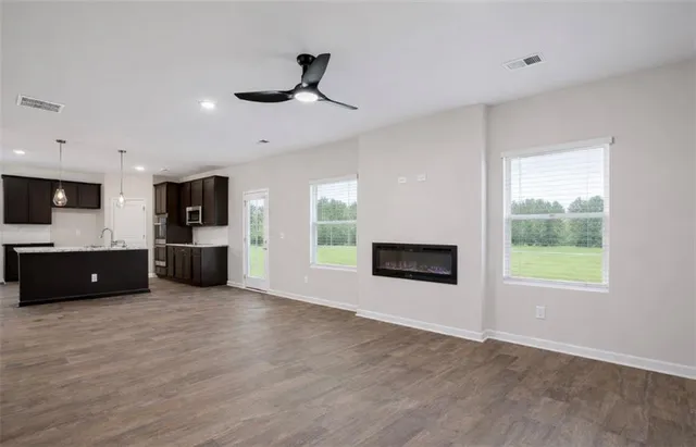 a view of a kitchen with stainless steel appliances wooden floor and windows