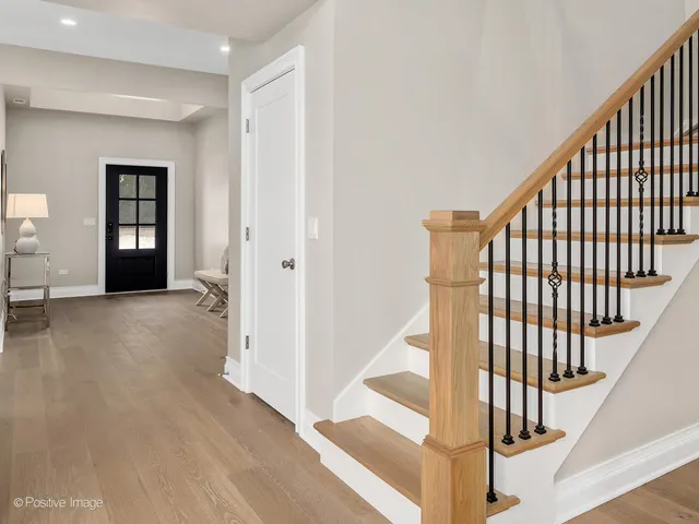 a view of a hallway with wooden floor and windows