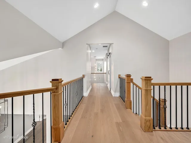 a view of a hallway with wooden floor and stairs